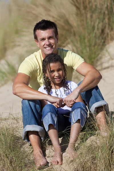 Мужчина и девочка, счастливые отец и дочь сидят на пляже — стоковое фото