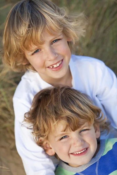Dois meninos, irmãos, juntos em uma praia ensolarada — Fotografia de Stock