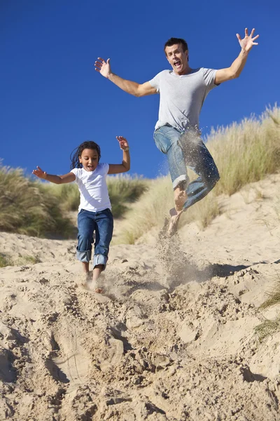 Man & meisje, gelukkig vader en dochter springen op strand — Stockfoto