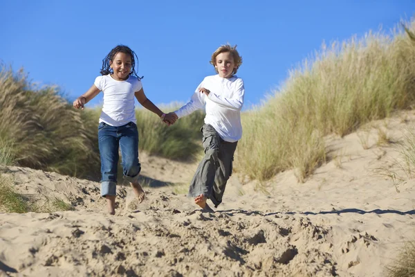 Loira menino & misto raça menina correndo no praia — Fotografia de Stock