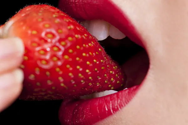 Mooie vrouwelijke lippen mond en tanden eten aardbei — Stockfoto