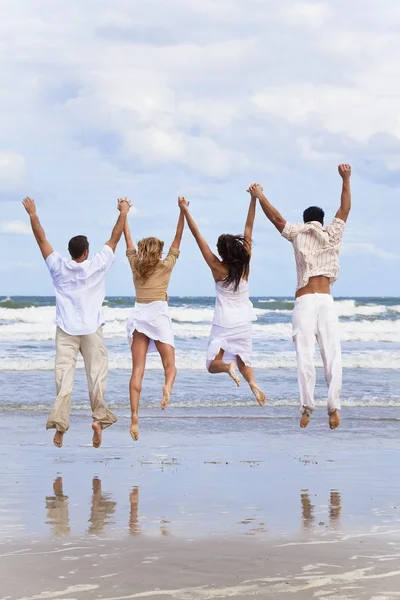 四个年轻人，两对情侣，海滩上跳跃庆祝 — 图库照片