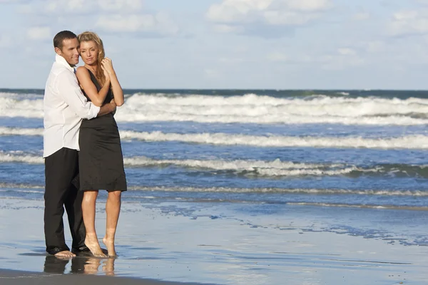 Muž a žena pár v romantické objetí na pláži — Stock fotografie