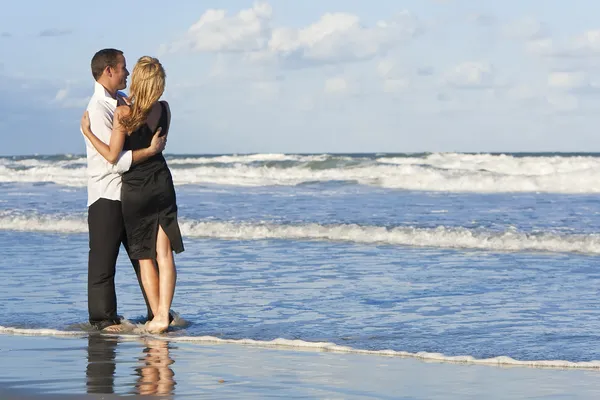 Чоловік і жінка пару сплячих, весело обіймаються на пляжі — стокове фото