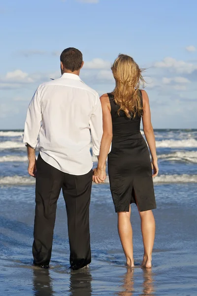 Mężczyzna i kobieta para trzymając się za ręce na plaży — Zdjęcie stockowe