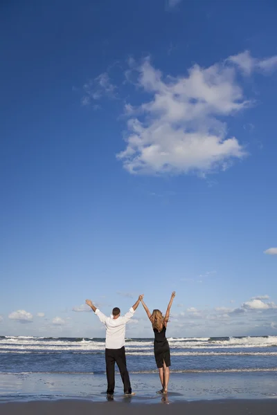 Man and Woman Couple Celebrating Arms Raised On A Beach — Stock Photo, Image