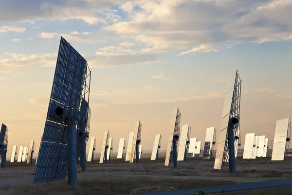 Painéis de espelho solar de energia verde ao pôr do sol ou ao nascer do sol — Fotografia de Stock