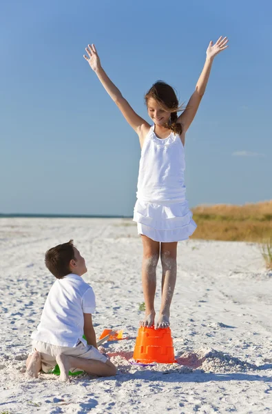 Zwei Kinder, Junge und Mädchen bauen Sandburgen am Strand — Stockfoto