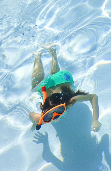 Ragazza che nuota sott'acqua in piscina con occhiali e boccaglio — Foto Stock