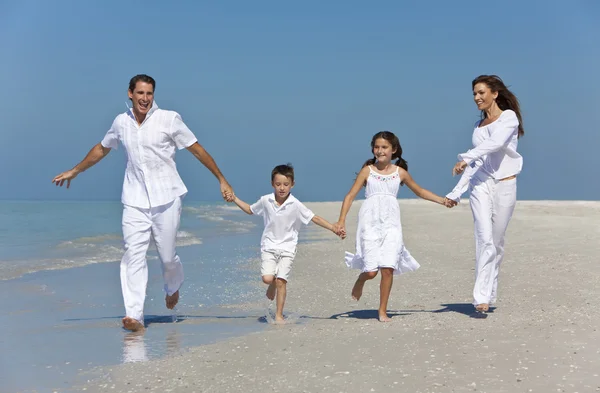 Mutter, Vater und Kinder laufen mit Spaß am Strand — Stockfoto