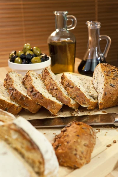 素朴なパン、オリーブ オイル、ぬいぐるみグリーン & 黒オリーブをスライス — ストック写真