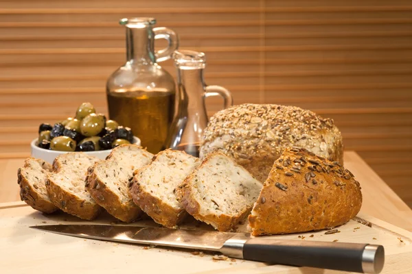 Čerstvé řezané Selský chléb, olivový olej & zelené a černé olivy — Stock fotografie