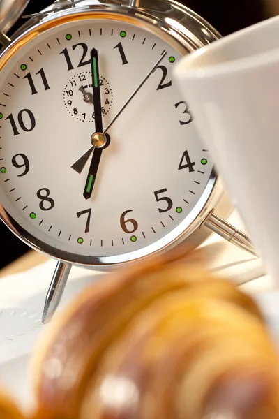 Reloj despertador y desayuno continental de croissant y café — Foto de Stock