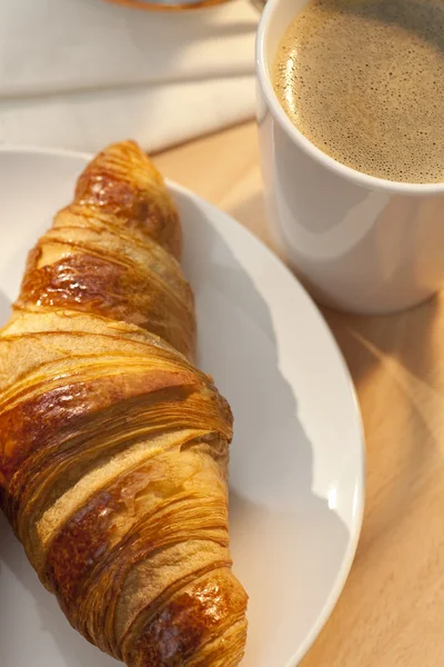 Continentaal ontbijt croissant en kopje koffie — Stockfoto