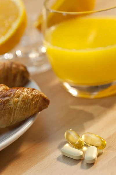 健康早餐牛角面包桔汁、 维生素 — 图库照片