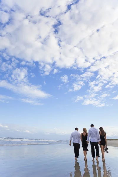 Cuatro jóvenes, Dos parejas, Caminando en una playa — Foto de Stock