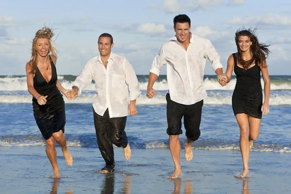 Τέσσερις νέοι, δύο ζευγάρια, διασκεδάζοντας τρέχει στην παραλία — Φωτογραφία Αρχείου