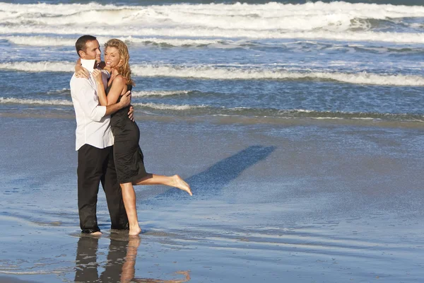 Hombre y mujer pareja en romántico abrazo en la playa — Foto de Stock
