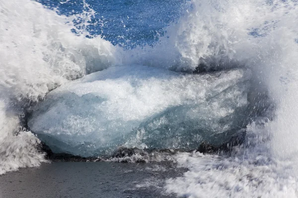 stock image Waves Breaking Against an Iceberg On Black Sand Beach, Iceland