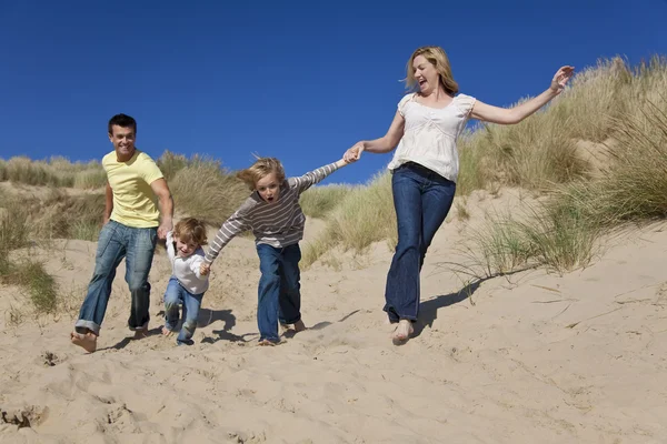 Mother, Father and Two Boys Running Having Fun At Beach Stock Image