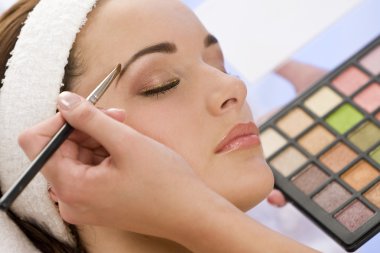 Beautiful Woman Having Make Up Applied by Beautician at Spa clipart