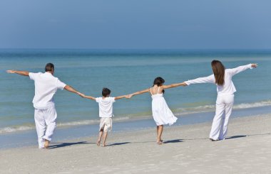 Mother, Father and Children Family Holding Hands At Beach clipart