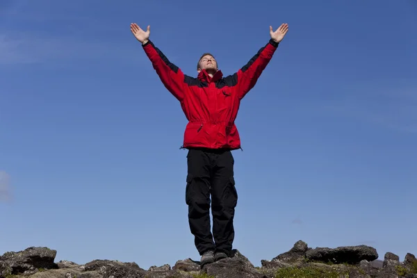 Человек празднует успех на вершине горы — стоковое фото