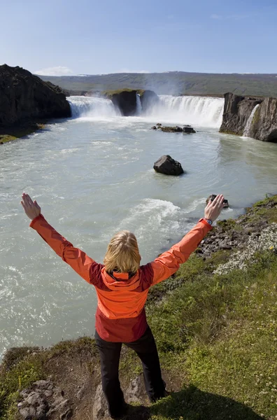 Mujer celebrando en la cascada Godafoss, Islandia — Foto de Stock