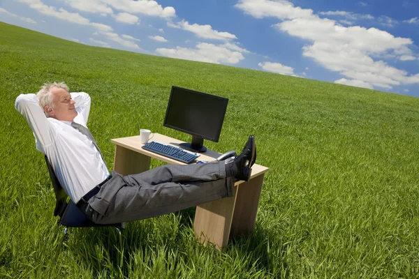 Επιχειρηματίας χαλαρώνοντας σε ένα πράσινο γραφείο — Φωτογραφία Αρχείου