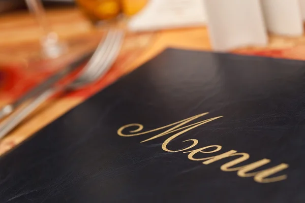 Menú & Cubertería en una mesa de restaurante — Foto de Stock