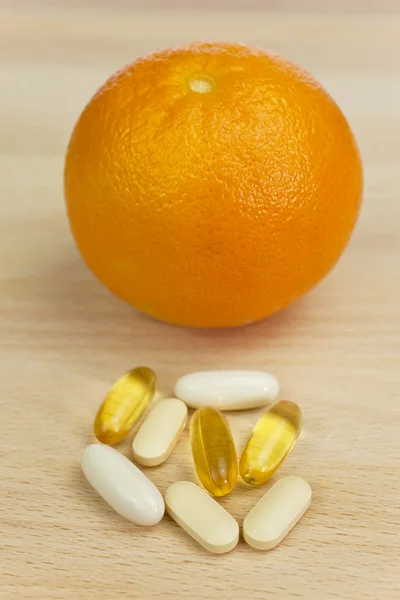 Таблетки апельсина и пищевых добавок или лекарства — стоковое фото