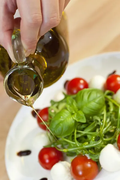 Olijfolie Dressing op Tomaat Mozzarella Rocket & basilicum salade — Stockfoto