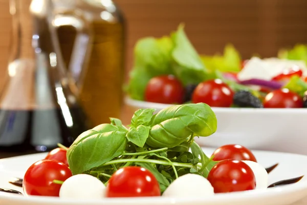 Tomaten-Mozarella-Rucola oder Rocquet-Salat mit Olivenöl und Ballen — Stockfoto