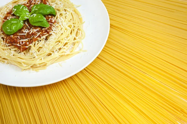 Piatto di Spaghetti Bolognese su un espositore soleggiato di pasta secca — Foto Stock