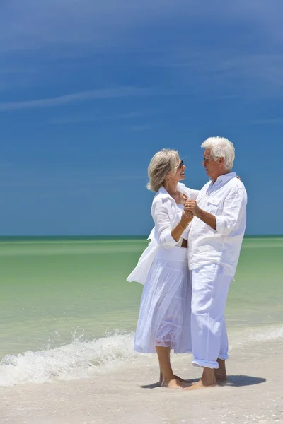 Tropik sahilde Holding dans kıdemli mutlu çift eller — Stok fotoğraf