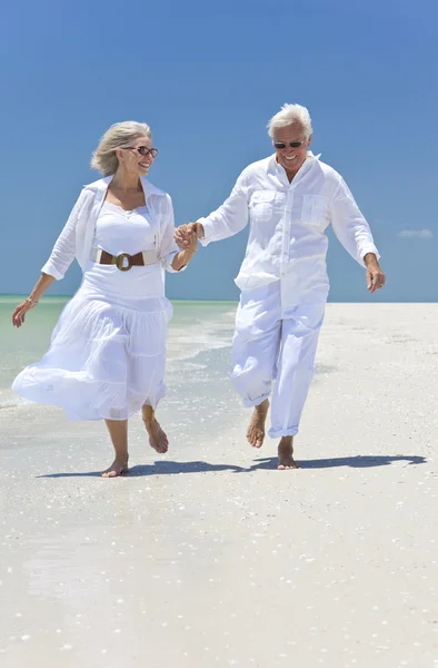 Щаслива пара старший, біг, тримаючись за руки на пляжі Tropical — стокове фото