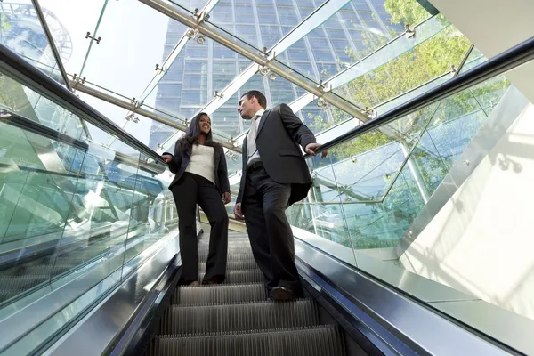 Executivos em uma escada rolante — Fotografia de Stock