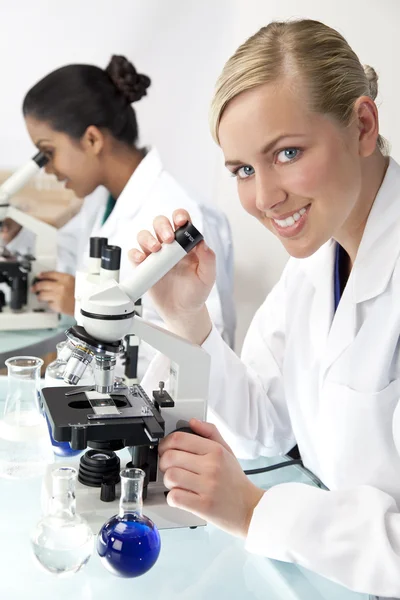 顕微鏡を使用して、研究所で女性の科学的な研究チーム — ストック写真