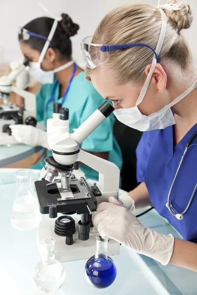 Kvinnliga vetenskaplig forskning team med Mikroskop i en laborator — Stockfoto