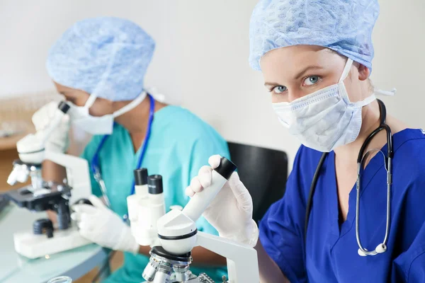 Vrouwelijke wetenschappers of artsen met behulp van microscopen in een laboratorium — Stockfoto
