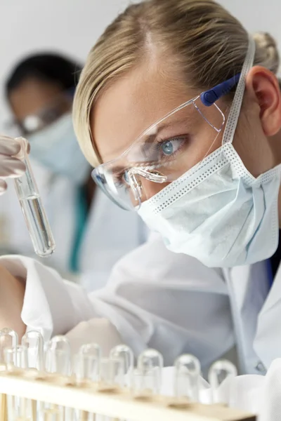 Pesquisadora científica feminina com solução clara em laboratório — Fotografia de Stock