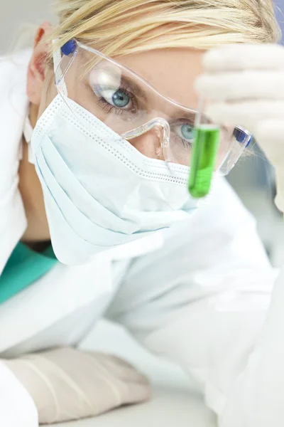 Cientista ou médica com tubo de teste verde em laboratório — Fotografia de Stock