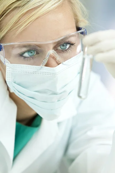 Médica cientista com tubo de teste de solução clara em laboratório — Fotografia de Stock