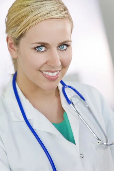 Atrakcyjny, uśmiechając się blond kobieta lekarz z stetoskop — Zdjęcie stockowe