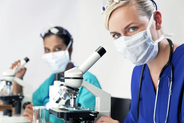 Gruppo di ricerca scientifica femminile che utilizza i microscopi in un laboratorio — Foto Stock