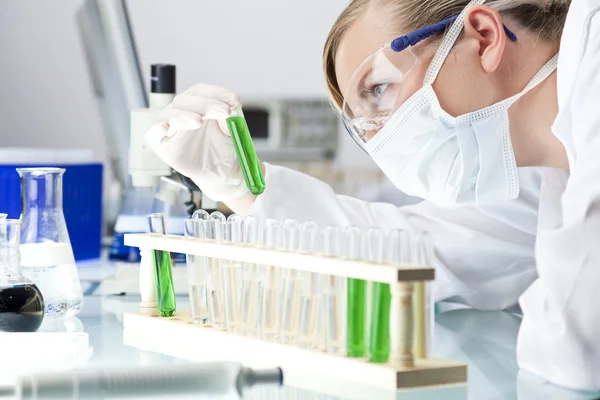 Cientista ou médica com solução verde em laboratório — Fotografia de Stock