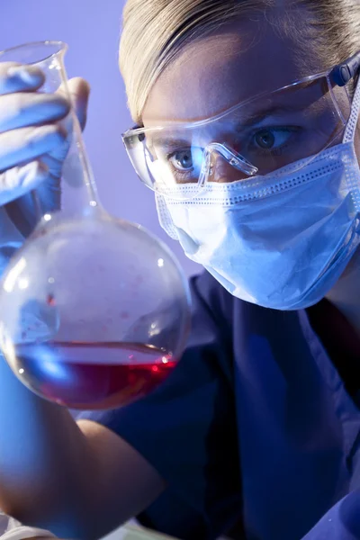 Wissenschaftlerin oder Ärztin mit roter Flüssigkeit im Labor — Stockfoto