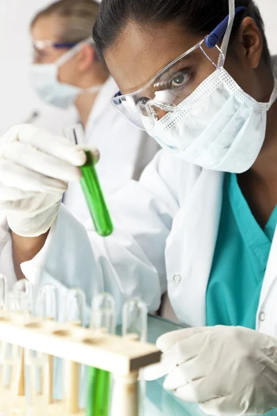 Equipo de investigación científica femenina con solución verde en laboratorio —  Fotos de Stock