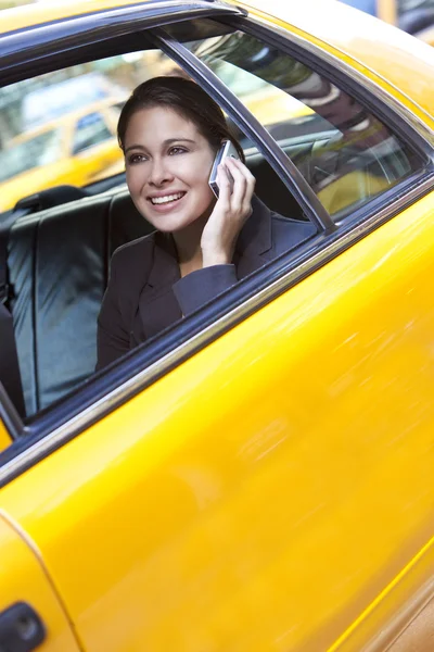 Νεαρή γυναίκα που μιλάμε για κινητό τηλέφωνο σε κίτρινο ταξί — Φωτογραφία Αρχείου