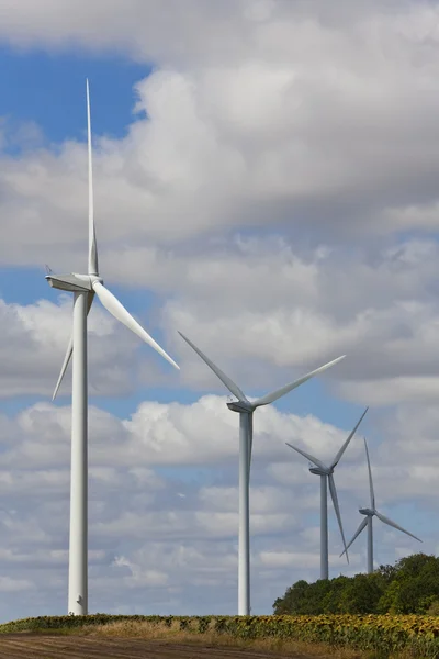 Turbinas eólicas de energia verde no campo de girassóis — Fotografia de Stock